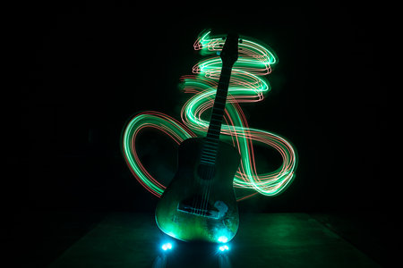 music concept. Acoustic guitar isolated on a dark background under beam of light with smoke with copy space. Guitar Strings, close up. selective focus.の写真素材