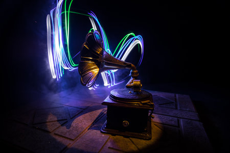 music concept. Old gramophone on a dark background. Retro gramophone with disc on wooden table with toned backlight. selective focusの写真素材