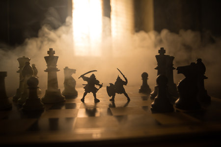 Medieval battle scene with cavalry and infantry on chessboard. Chess board game concept of business ideas and competition and strategy ideas Chess figures on a dark background with smoke and fog.の写真素材