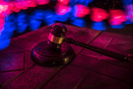 Law theme, mallet of the judge on wooden desk. Law gavel on dark foggy background with light. selective focusの写真素材