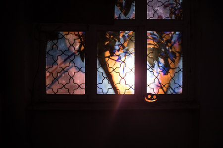 Scary Halloween pumpkin in the mystical house window at night or halloween pumpkin and horror...