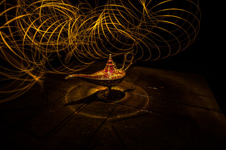 Antique Aladdin arabian nights genie style oil lamp with soft light white smoke, Dark background. Lamp of wishes conceptの写真素材