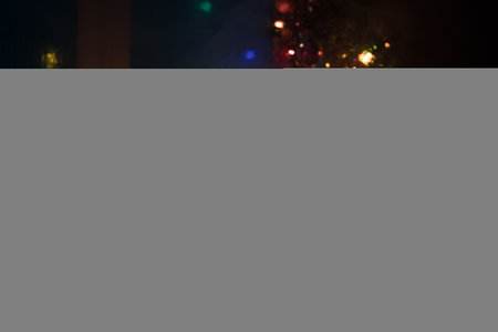 Christmas and New year concept.Fir tree standing on red carpet with traditional holiday attributes. Cozy window with colorful lights on background. selective focusの写真素材