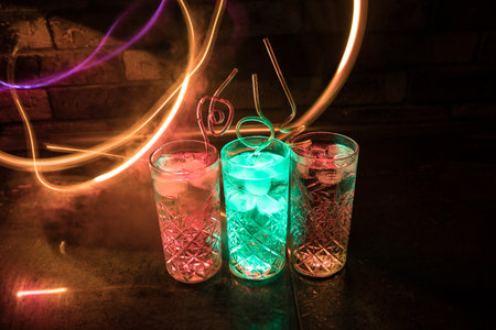 colorful cocktail in glass on dark background or Glasses of cocktails on bar background.Party club entertainment. mixed lightの写真素材