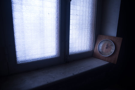 time concept. Old rustic wall clock on grunge dirty windowsill. studio shot.の写真素材