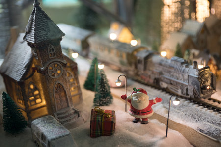 Miniature of winter scene with Christmas houses, train station, trees, covered in snow. night scene. New year vintage toy city. selective focusの写真素材
