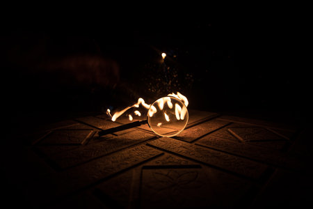 Magnifying glass on stone surface in dark background, under the light, mysterious detective conceptの写真素材