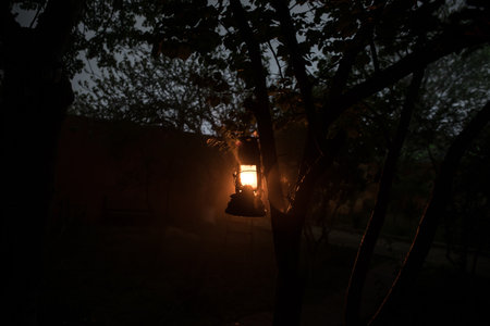Beautiful colorful illuminated lamp in the garden in misty night. Retro style lantern at night outdoor. selective focusの写真素材