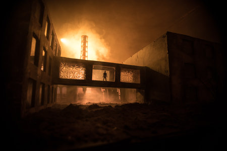 Creative artwork decoration. Chernobyl nuclear power plant at night. Layout of abandoned Chernobyl station after nuclear reactor explosion. Man silhouette in window. Selective focusの写真素材
