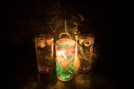 colorful cocktail in glass on dark background or Glasses of cocktails on bar background.Party club entertainment. mixed lightの写真素材