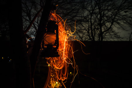 Beautiful colorful illuminated lamp in the garden in misty night. Retro style lantern at night outdoor. selective focusの写真素材