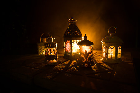 Arabian tea in glass with eastern snacks on a stone surface on dark background with lights and smoke. Eastern tea concept. selective focus.の写真素材