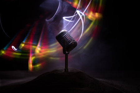 Microphone for sound, music, karaoke in audio studio or stage. Mic technology. Speech broadcast equipment. Microphone in dark room on table with backlight. selective focusの写真素材