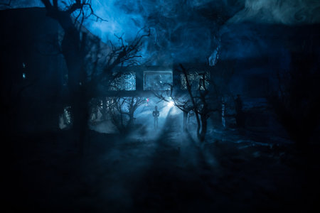 Silhouette of person standing in the dark forest with light. Horror halloween concept. strange silhouette at abandoned buildingの写真素材