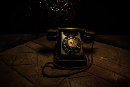 old black telephone on old wood plank with art dark background with fog and toned light. empty...