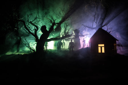 Silhouette of person standing in the dark forest with light. Horror halloween concept. strange silhouette in a dark spooky villageの写真素材