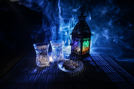 Suhoor or iftar time during Ramadan fasting. A glass of water and dates to break the fast. Festive...