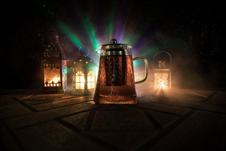 Arabian tea in glass with eastern snacks on a stone surface on dark background with lights and smoke. Eastern tea concept. selective focus.の写真素材