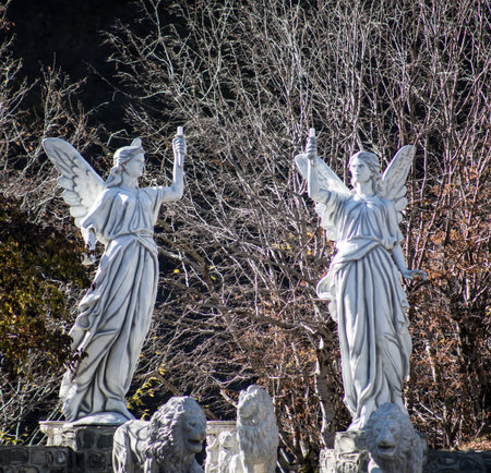 Statue of a graceful angel mourning over a grave in cemetery surrounded by trees. Azerbaijan natureの写真素材