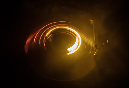 Music DJ concept. Trail of fire and smoke on vinyl record. Burning vinyl disk. Turntable vinyl record player on dark background. selective focusの写真素材