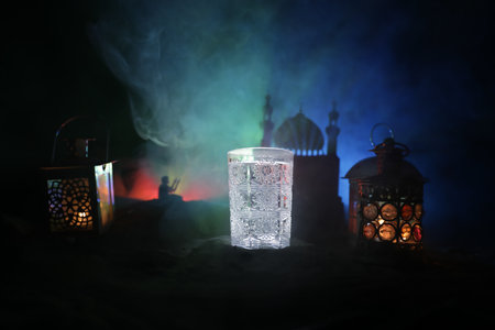 Suhoor or iftar time during Ramadan fasting. A glass of water and dates to break the fast. Festive...