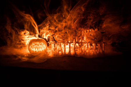 Halloween concept. Halloween pumpkin head in dark on table. Toned light with fog on background....