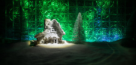Christmas home decoration with snow and tree on a dark background with copy space. Cozy lights in selective focus. New Year attributes on backgroundの写真素材