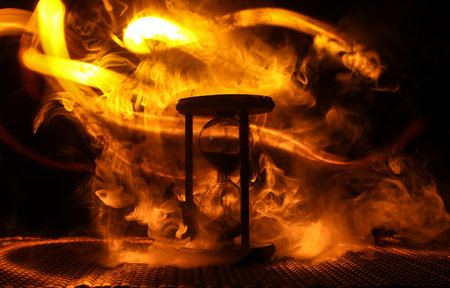 Hourglass as time passing concept for business deadline, urgency and running out of time. Sandglass, egg timer on dark background showing the last second or last minute or time out. With copy space.の写真素材