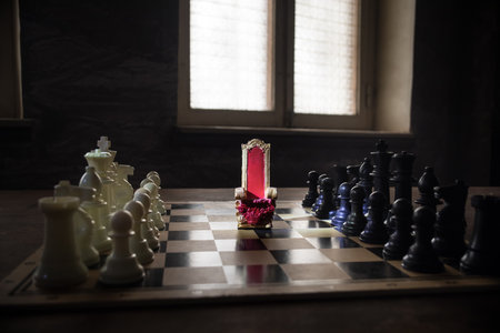 Red royal chair (Medieval Throne) miniature on chessboard. . Chess board game concept of business ideas and competition and strategy ideas concept. selective focusの写真素材