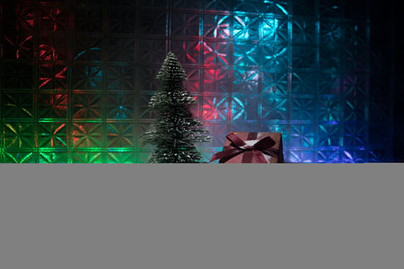 Christmas home decoration with snow and tree on a dark background with copy space. Cozy lights in selective focus. New Year attributes on backgroundの写真素材