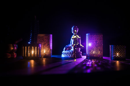 Yoga Concept with Namaste Statue and Oriental-Inspired Miniature on Table. Miniature in selective focusの写真素材