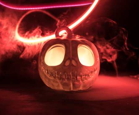 Halloween concept. Halloween pumpkin head in dark on table. Toned light with fog on background....