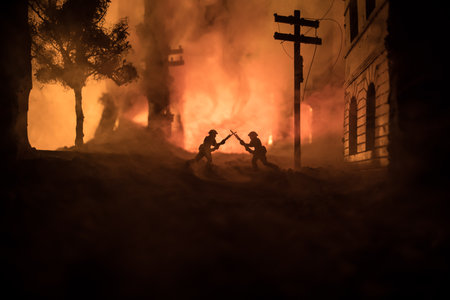 Soldiers with large caliber rifles standing in the fire and smoke. Battle scene on fire background, Fighting silhouettes Below Cloudy Skyline at night. City destroyed by warの写真素材