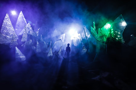 A silhouette of a person against the background of shattered glass. An abstract world made of glass shards. Surreal concept. Table top decoration. Selective focusの写真素材