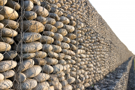 Wall of pebbles and stones in the iron gridの写真素材
