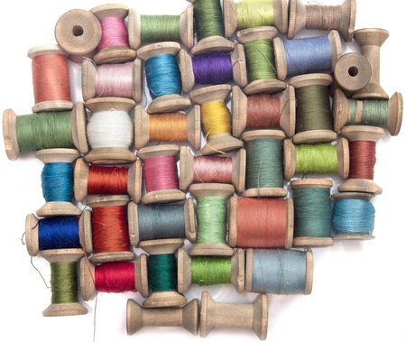 thread for sewing on wooden spools on a white background, handcraft, top viewの写真素材