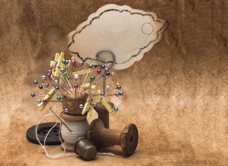 vintage accessories for sewing, wooden spools of thread, buttons and a metal thimble, needles and pins, retro style, work, hobbyの写真素材