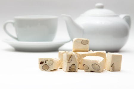 Oriental sweets with nuts on the background of the tea kettle and white Cupの写真素材
