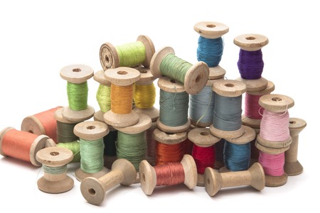 set of colored thread for sewing on wooden spools, vintage, white backgroundの写真素材