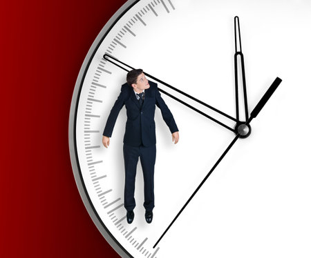 Businessman hangs on an arrow of clock, isolated on red backgroundの写真素材