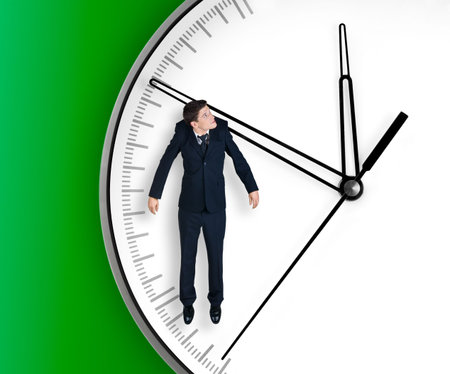 Businessman hangs on an arrow of clock, isolated on green backgroundの写真素材