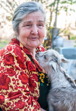 Senior woman holding a goatling の写真素材
