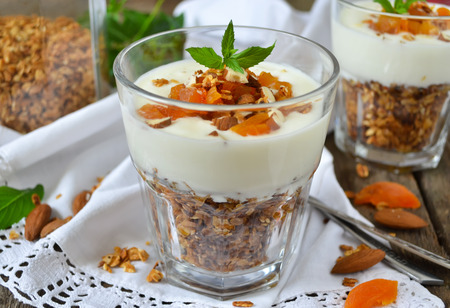 Baked muesli or oatmeal with almonds, served with yoghurt and dried apricotsの写真素材