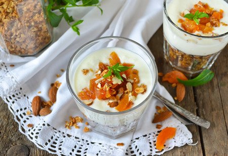 Baked granola or oatmeal with almonds, served with yoghurt and dried apricotsの写真素材