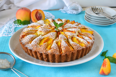 Delicate cake with peaches, dusted with icing sugarの写真素材