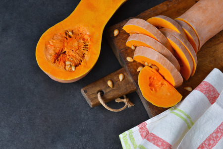 The cut pieces of pumpkin on a black background with space for text. Top view .の写真素材