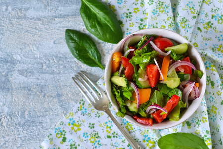 Vegetable salad with spinach, tomato and cucumber on a concrete background. Top view.の写真素材