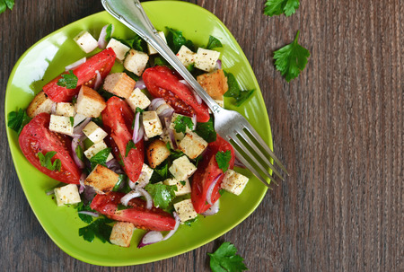 Vegetable salad with feta cheese and crackers on a brown backgroundの写真素材