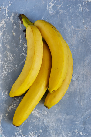 A bunch of bananas on a gray concrete background, top viewの写真素材