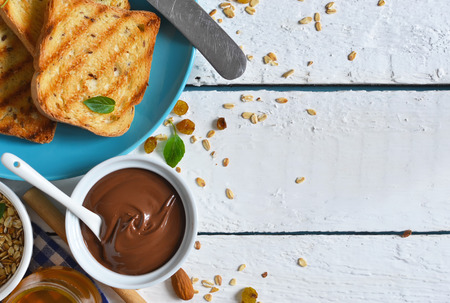 Good morning - toast with Nutella, banana and honey. White food background.